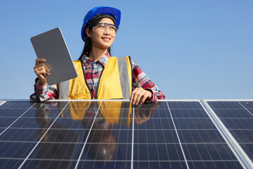 Electrical engineer holding a tablet with the solar panel outdoors.