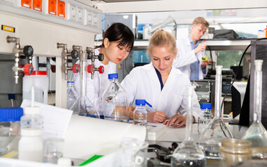 Fototapeta premium Portrait of group of European and Chinese scientists working together at biochemical laboratory