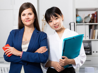 Portrait of two successful confident business women in office interior. High quality photo