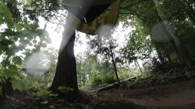 Mountain biker takes hard crash as he goes around turn on muddy spring day - first person view
