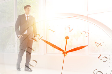Double exposure of clock and young businessman in office
