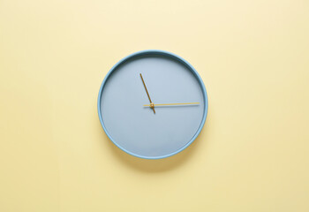 Stylish clock hanging on color wall