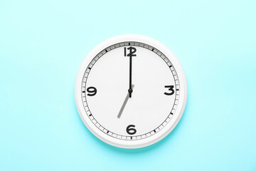 Stylish clock hanging on color wall