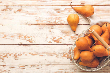 Basket with fresh ripe pears on wooden background