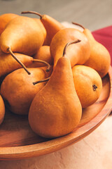 Board with fresh ripe pears on table