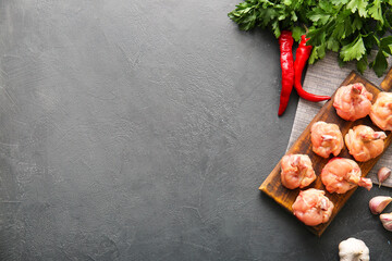 Board with raw chicken lollipops on dark background