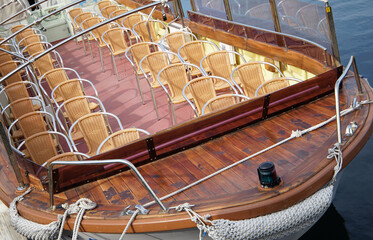 A sightseeing boat with many chairs lined up on the deck