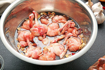 Bowl with raw chicken lollipops  on dark background, closeup
