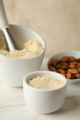 Bowl with almond flour on light background