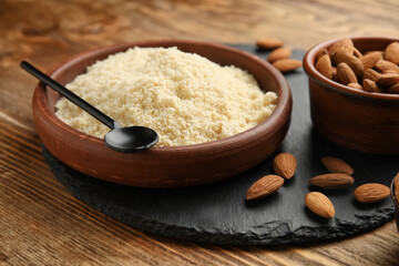 Bowl with almond flour on wooden background