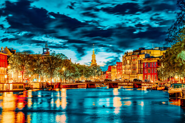 Famous Amstel river and night view of beautiful Amsterdam city. Netherlands