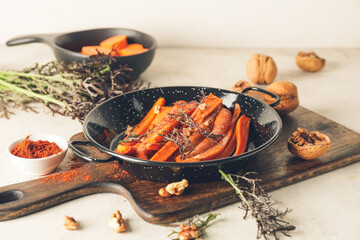 Dish of tasty baked carrot on light background