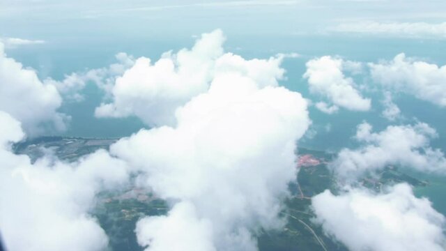 Aerial View From The Airplane Flyng From Australia to Singapore - Flying Over The Layer Of Clouds And Looking On Landscape Through The Clouds - POV