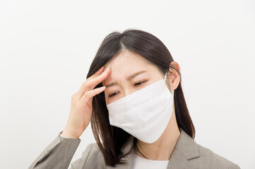 体調不良でマスクを着けた女性