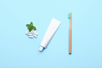 Chewing gums, toothbrush and paste on color background