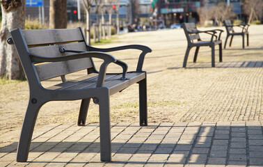 A park on a sunny day lined with benches