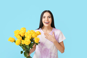 Beautiful surprised young woman with bouquet of roses on color background