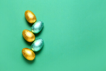Sweet chocolate eggs on color background