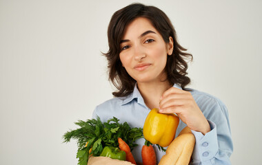 Cheerful pretty woman in a shirt with a package of products household healthy food delivery