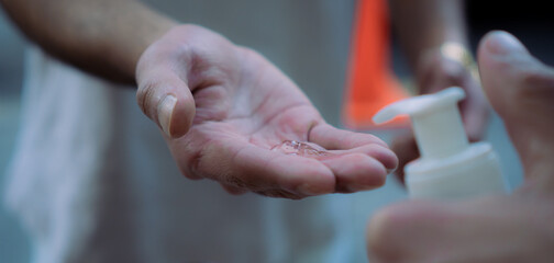 Hands of young man applying antibacterial gel, coronavirus concept