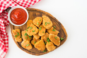 Homemade chicken nuggets with ketchup on a wooden board, top view