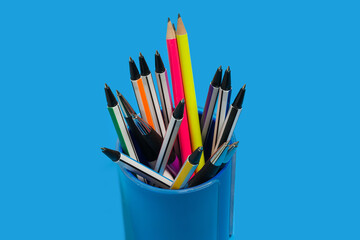 pens and pencils lying in a blue penholder