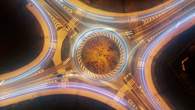 Fast data traffic lines on roundabout with fast moving cars. Top view drone hyperlapse at night.