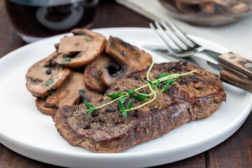 Beef steak with sauteed brown mushrooms and thyme, horizontal