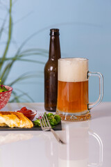 Beer mug with empty beer bottle and a grilled sandwich