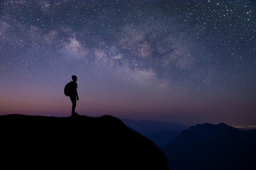 Silhouette of young traveler and backpacker watched the star and milky way on top of the mountain...