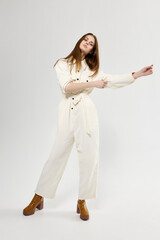 pretty woman gesturing with her hands in white jumpsuit fashion