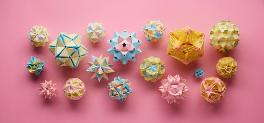 Set of multicolor handmade modular origami balls or Kusudama Isolated on pink background. Visual...