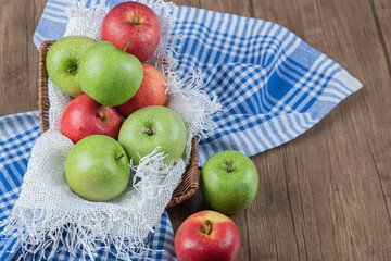 Red and green apples in a wooden container