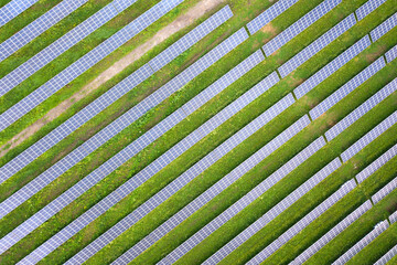 Aerial view of solar power plant on green field. Electric panels for producing clean ecologic energy.