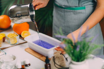 Pouring Purple Liquid Homemade Soap Mass into Silicone Mold.