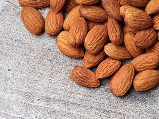 Almond in a bowl on wooden background with copy space