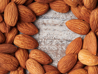 Almond in a bowl on wooden background with copy space