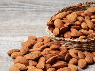 Almond in a bowl on wooden background with copy space