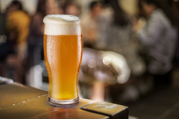 Glass of unfiltered beer stands on a table in a pub.