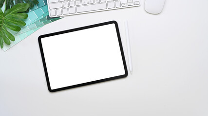 Mock up digital tablet with blank screen, keyboard, color swatches and copy space on white background.