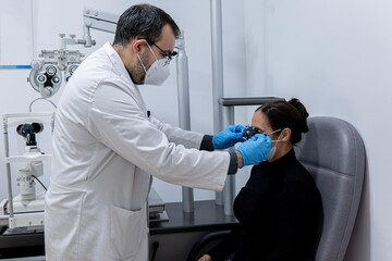Optician measuring a woman's eyesight