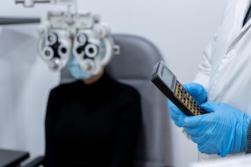 Young patient eye examination at optometrist using phoropter