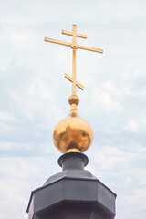 The gold cross over church top easter light overcast background