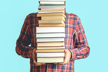 Student with books on a blank colored background. Education, reading and study background concept