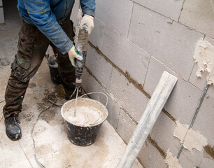 A worker kneads the mixture into plaster buckets. Home renovation