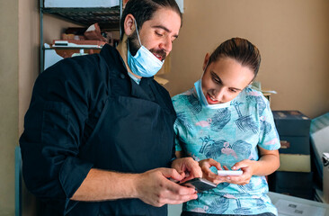Chef and waitress looking at mobile at work break