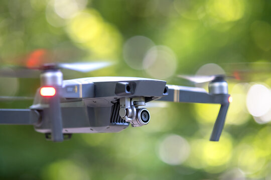 Drone Copter With Blurred Propellers And Video Camera Flying In Air.