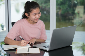 Education learning online concept, Teenage student using computer studying online. New normal style. Teen girl using computer laptop to self learning online.