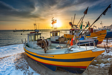 Fishing boat on the beach of Mechelinki by the Baltic Sea at sunrise, Poland.