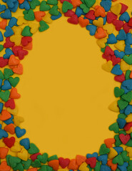  Easter Egg form from colorful heart shape sweet candy on bright yellow background.  Happy Easter Day card concept. Copy space for text. Minimal concept.